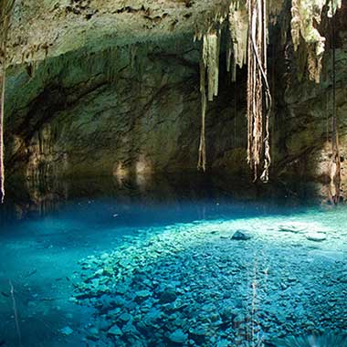 Oświetlony podziemny zbiornik wody skrzący się na niebiesko. Wody podziemne zazwyczaj zawierają sód ze względu na obecność minerałów skalnych w wodzie.